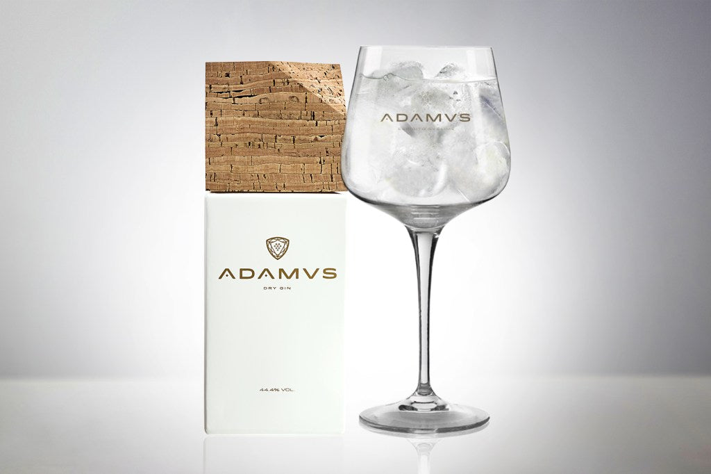 Adamus Gin Tonic im Ballonglas neben der Adamus-Verpackung