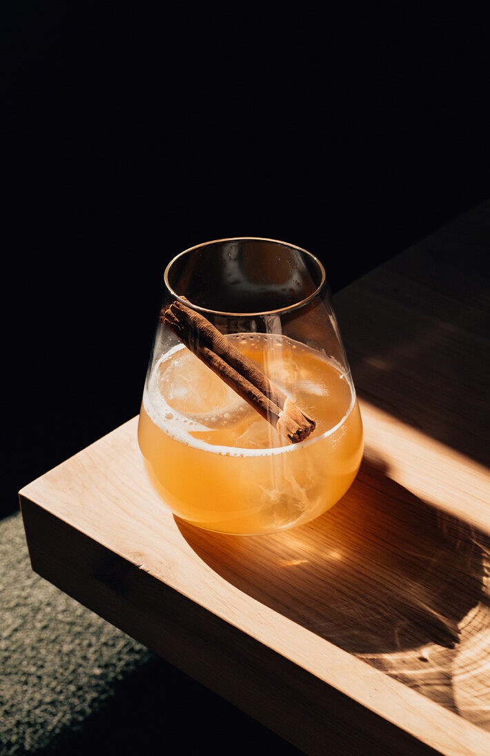 Alkoholfreier Apple Fizz mit Zimtstange und Apfelscheiben