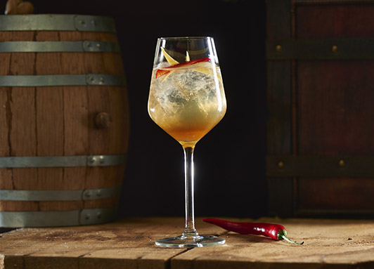 Falernum und Tonic im Longdrinkglas mit Zitrone
