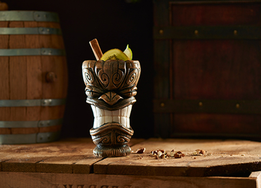 Tiki-Cocktail mit Zimtstange und Limette
